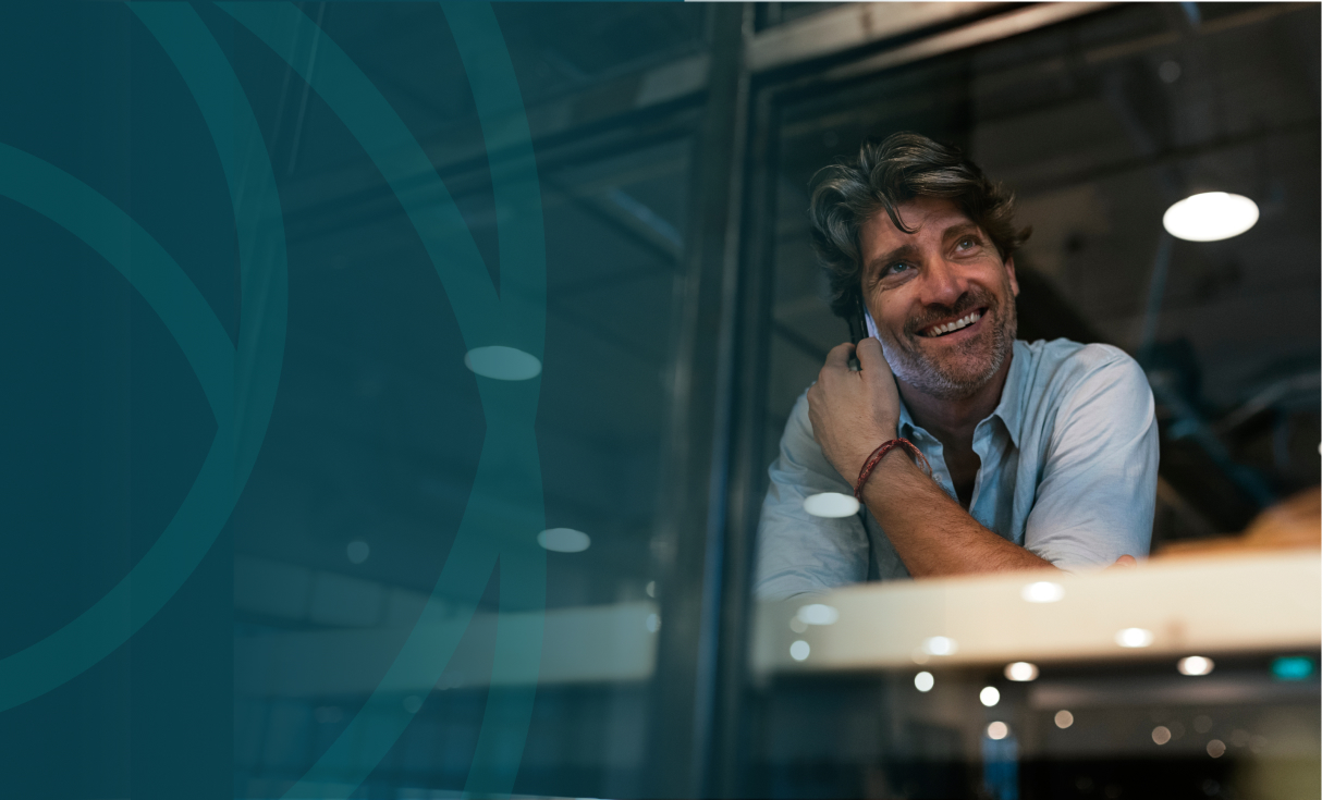 business man on phone smiling looking through window