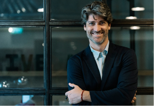 man in office smiling with arms crossed